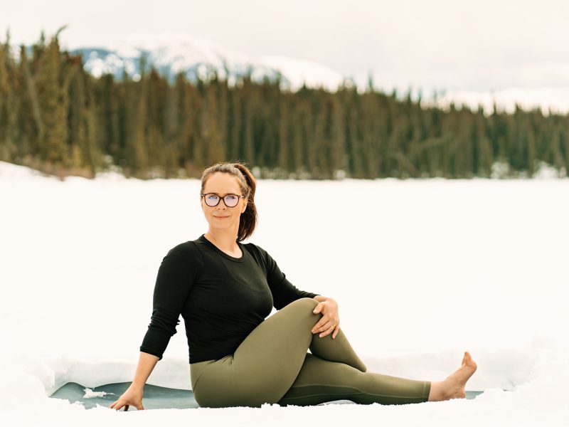 Amite Yoga – Winter Session 84 of 111 Yogi sitting in snow doing seated side twist